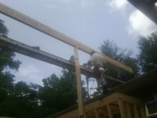 Carpenter setting a ridge beam over a new addition frame — Ice Dam Removal by Roofing Brothers in Brooktondale
