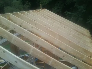 New roof rafters set over an addition before sheathing in Brooktondale