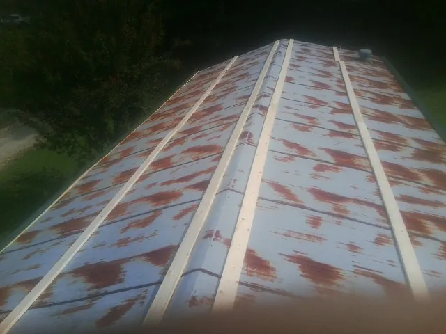 Rusted metal roof panels with new wood purlins before replacement — Storm Damage Roof Repair in Brooktondale by Roofing Brothers
