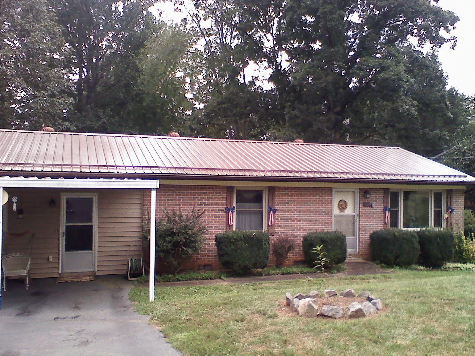Bronze metal roof and carport on a brick ranch home — Roof Repair work by our crew in Brooktondale